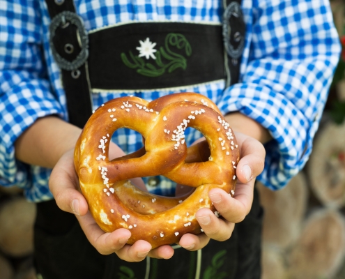 Close up of pretzel in the boy hands wearing a traditional bavarian clothes during Oktoberfest in Fredericksburg TX